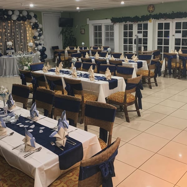 Nipa Hut Bar & Restaurant's dining room set for an event with tables, chairs, and balloon decor.